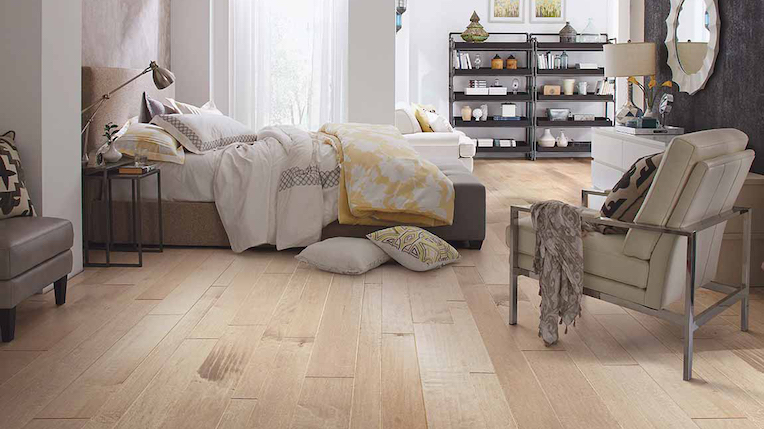 wide planked hardwood flooring in a spacious bedroom
