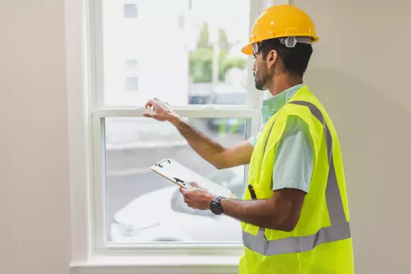 Stock photo featuring installer working on windows inside a home. 